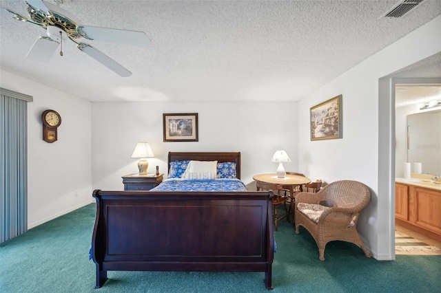 carpeted bedroom featuring ceiling fan, sink, a textured ceiling, and ensuite bath