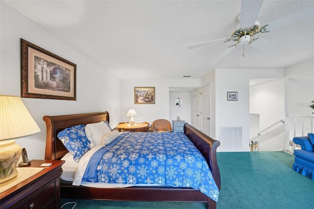 carpeted bedroom featuring ceiling fan and a textured ceiling