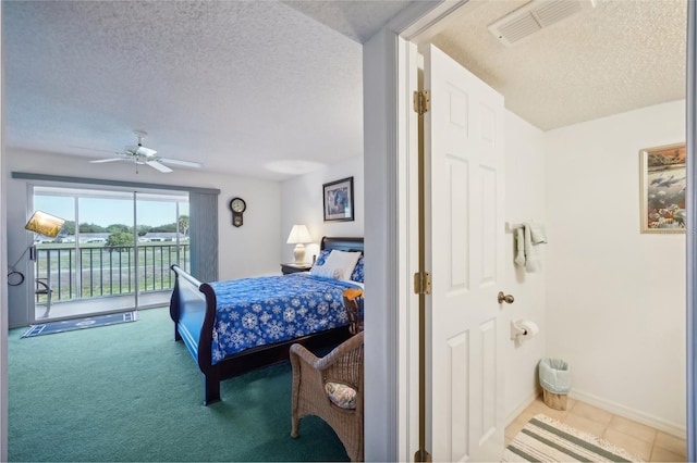 carpeted bedroom with ceiling fan, access to exterior, and a textured ceiling