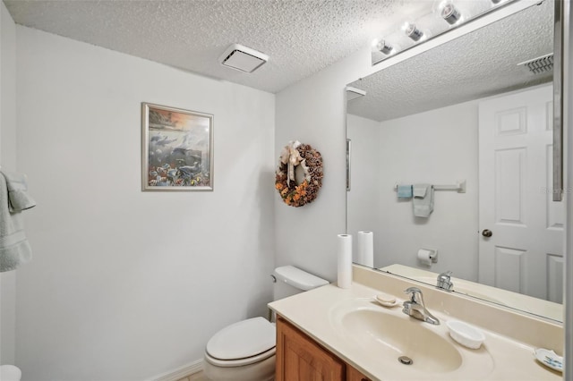 bathroom with vanity, a textured ceiling, and toilet