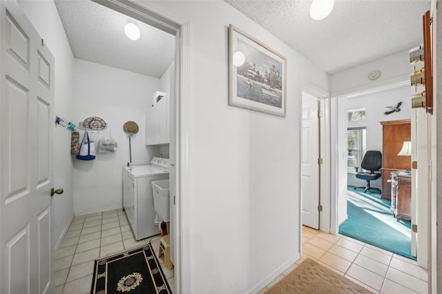 bathroom featuring washing machine and clothes dryer, tile patterned flooring, and a textured ceiling