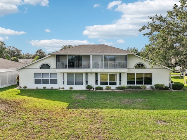 rear view of property featuring a lawn