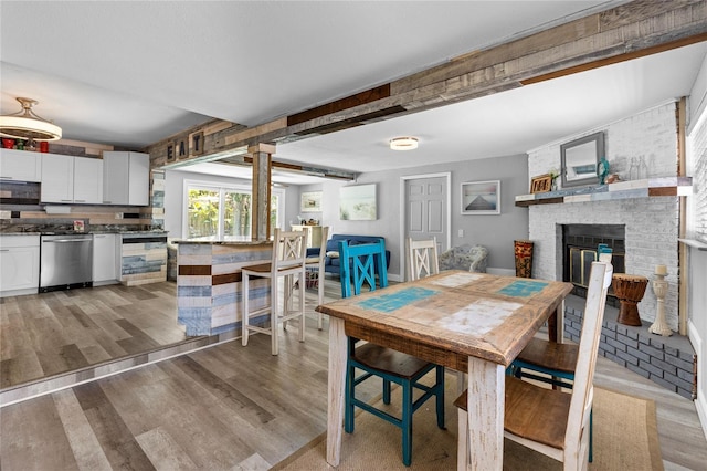 dining space featuring a fireplace and light wood-type flooring