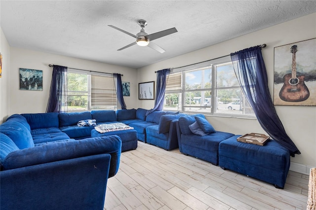 living room with ceiling fan, light hardwood / wood-style floors, and a textured ceiling