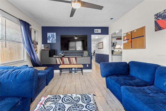 living room featuring ceiling fan, a healthy amount of sunlight, and light hardwood / wood-style flooring