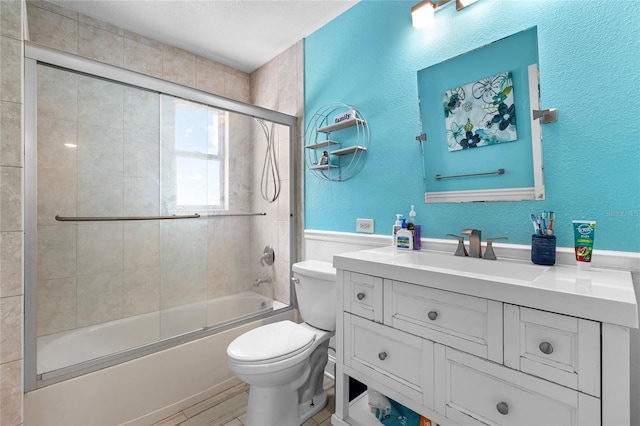 full bathroom featuring vanity, toilet, and shower / bath combination with glass door