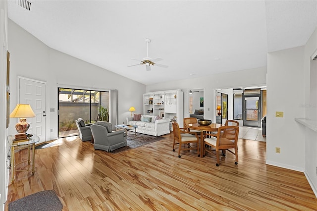 living room featuring ceiling fan, lofted ceiling, and light hardwood / wood-style flooring