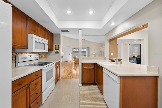 kitchen with sink, tasteful backsplash, a raised ceiling, crown molding, and white appliances