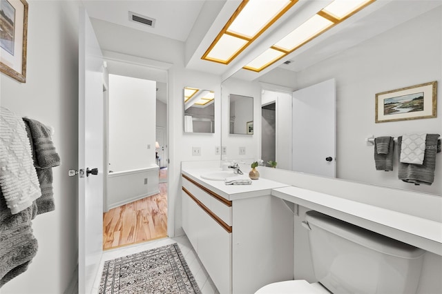 bathroom with tile patterned flooring, vanity, and toilet