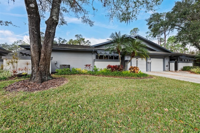 ranch-style house featuring a garage and a front lawn