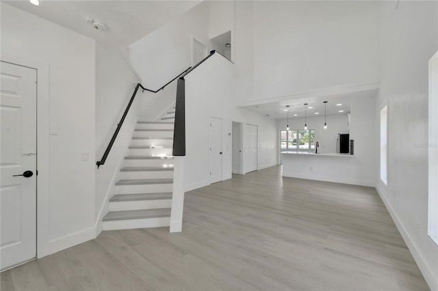 stairway with hardwood / wood-style floors and sink