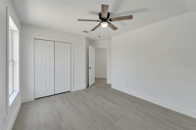 unfurnished bedroom featuring a closet, ceiling fan, and light hardwood / wood-style flooring