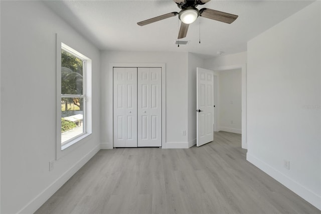 unfurnished bedroom with multiple windows, ceiling fan, a closet, and light hardwood / wood-style floors