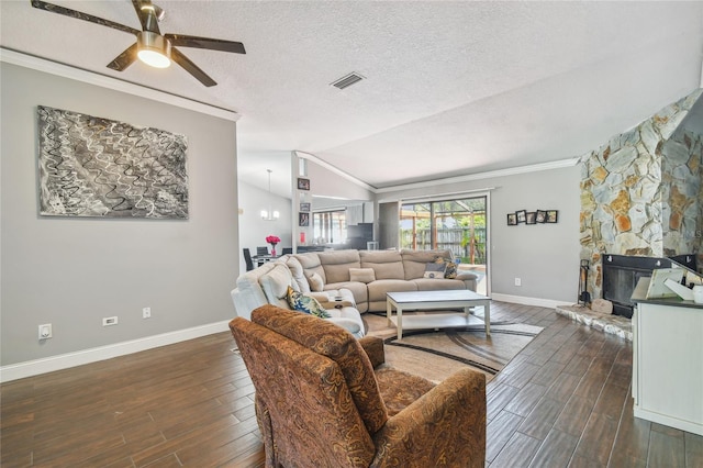 living room featuring ceiling fan, dark hardwood / wood-style flooring, vaulted ceiling, a fireplace, and ornamental molding