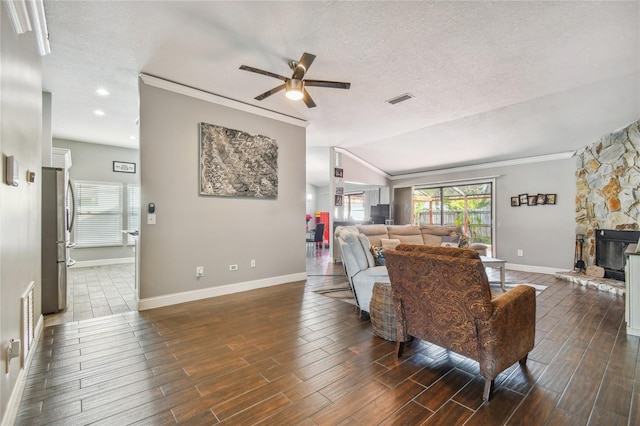 living room with ceiling fan, a healthy amount of sunlight, a fireplace, and vaulted ceiling