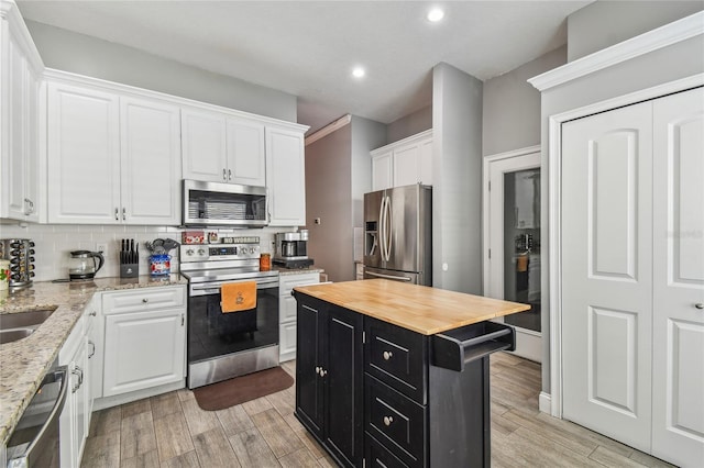 kitchen with backsplash, a center island, white cabinetry, and stainless steel appliances