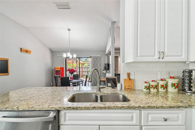 kitchen featuring light stone countertops, sink, backsplash, vaulted ceiling, and white cabinets