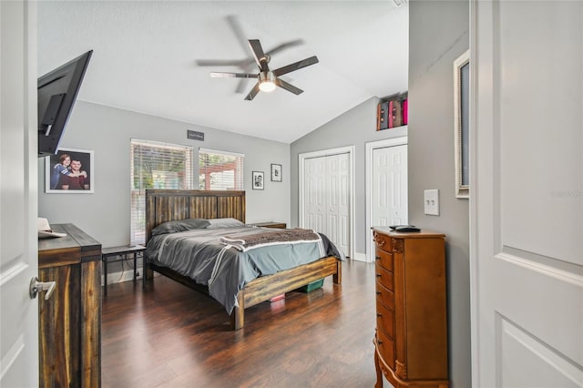 bedroom featuring hardwood / wood-style floors, ceiling fan, lofted ceiling, and multiple closets