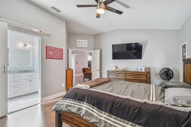 bedroom with connected bathroom, ceiling fan, sink, light hardwood / wood-style floors, and vaulted ceiling