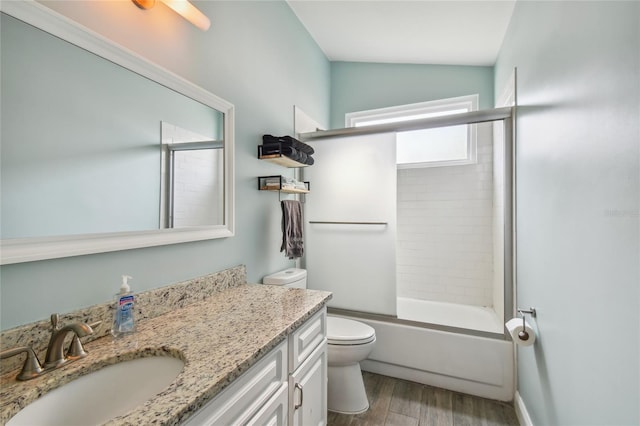 full bathroom featuring hardwood / wood-style floors, vanity, toilet, and bath / shower combo with glass door