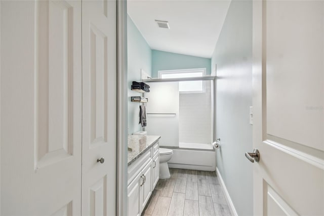 full bathroom featuring washtub / shower combination, vanity, vaulted ceiling, and toilet