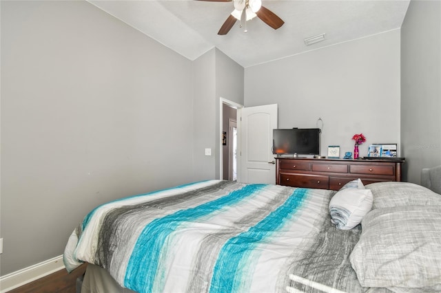 bedroom featuring ceiling fan, dark hardwood / wood-style floors, and vaulted ceiling