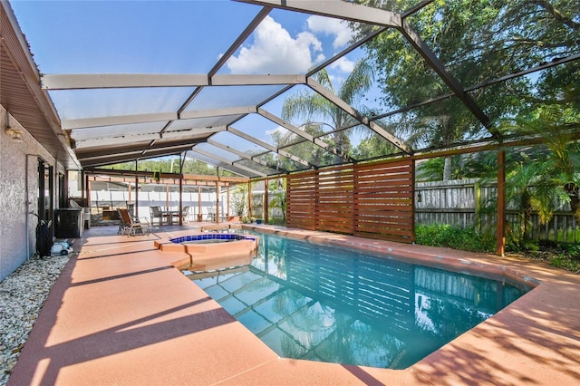 view of swimming pool featuring a lanai, a patio area, and an in ground hot tub