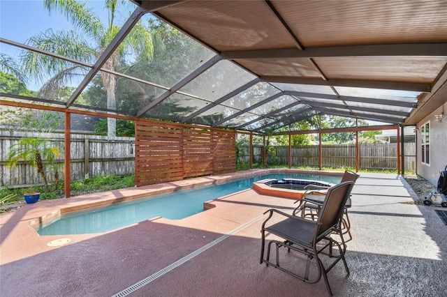 view of swimming pool featuring a lanai, an in ground hot tub, and a patio