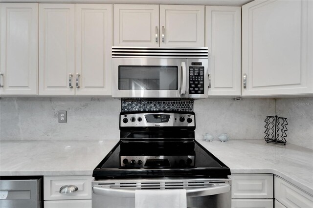 1028 Apollo Beach Blvd Unit 27, Apollo Beach, FL 33572 - kitchen with appliances with stainless steel finishes, white cabinetry, and backsplash