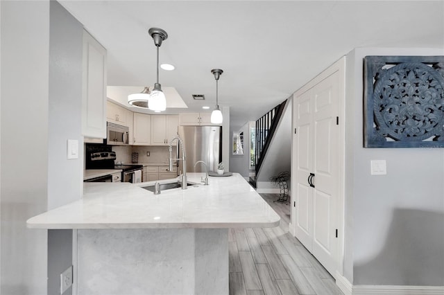 1028 Apollo Beach Blvd Unit 27, Apollo Beach, FL 33572 - kitchen featuring appliances with stainless steel finishes, pendant lighting, a peninsula, recessed lighting, and white cabinetry