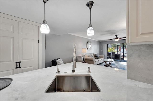 kitchen with ceiling fan, hanging light fixtures, crown molding, and sink