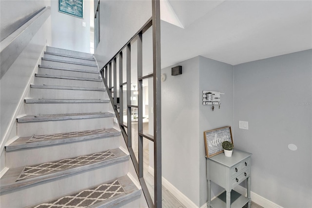 stairs featuring a wealth of natural light and hardwood / wood-style flooring