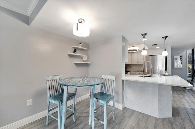 1028 Apollo Beach Blvd Unit 27, Apollo Beach, FL 33572 - kitchen featuring freestanding refrigerator, wood finish floors, white cabinetry, light countertops, and hanging light fixtures