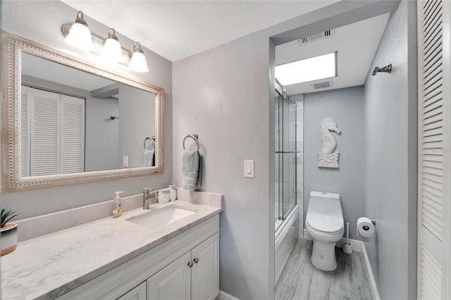 1028 Apollo Beach Blvd Unit 27, Apollo Beach, FL 33572 - full bath featuring a closet, vanity, wood finished floors, and combined bath / shower with glass door