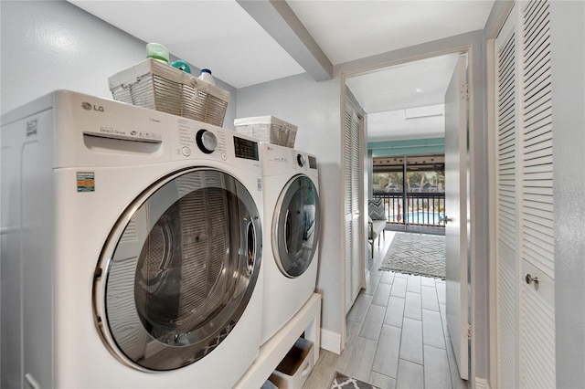 clothes washing area featuring washer and dryer and light wood-type flooring