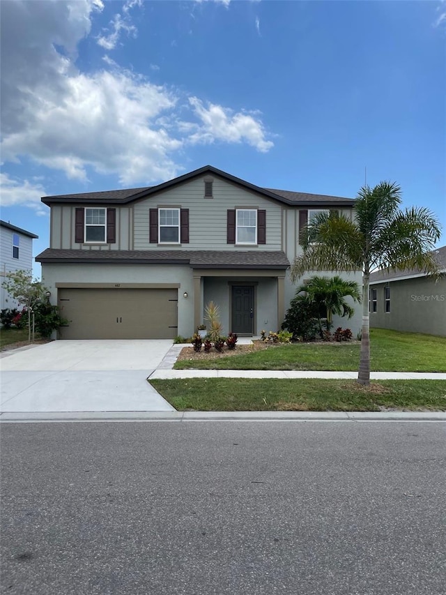 view of front of house featuring a front lawn and a garage