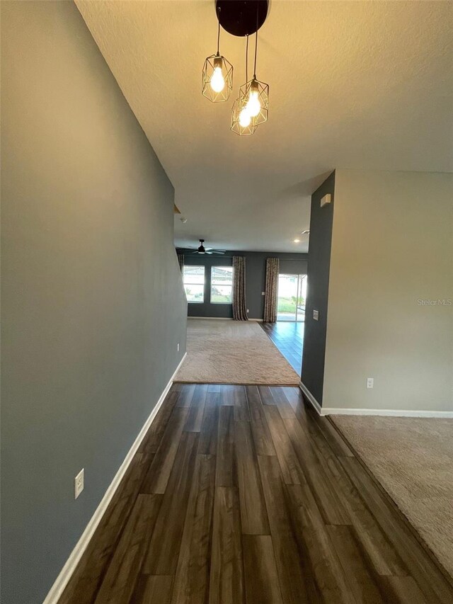 hall featuring a textured ceiling and dark wood-type flooring