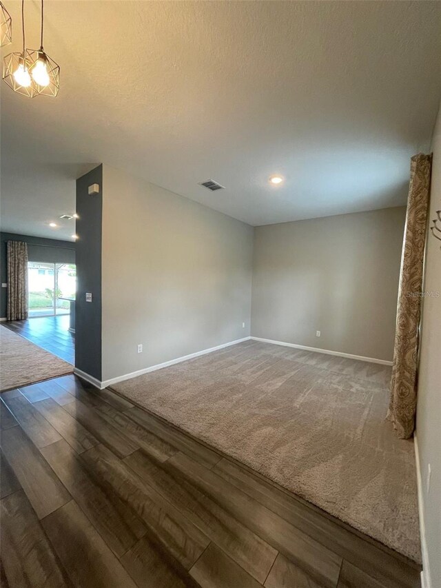 unfurnished room with dark hardwood / wood-style floors and a textured ceiling