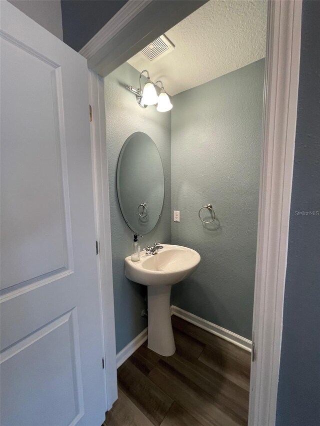 bathroom featuring sink, a textured ceiling, and hardwood / wood-style flooring