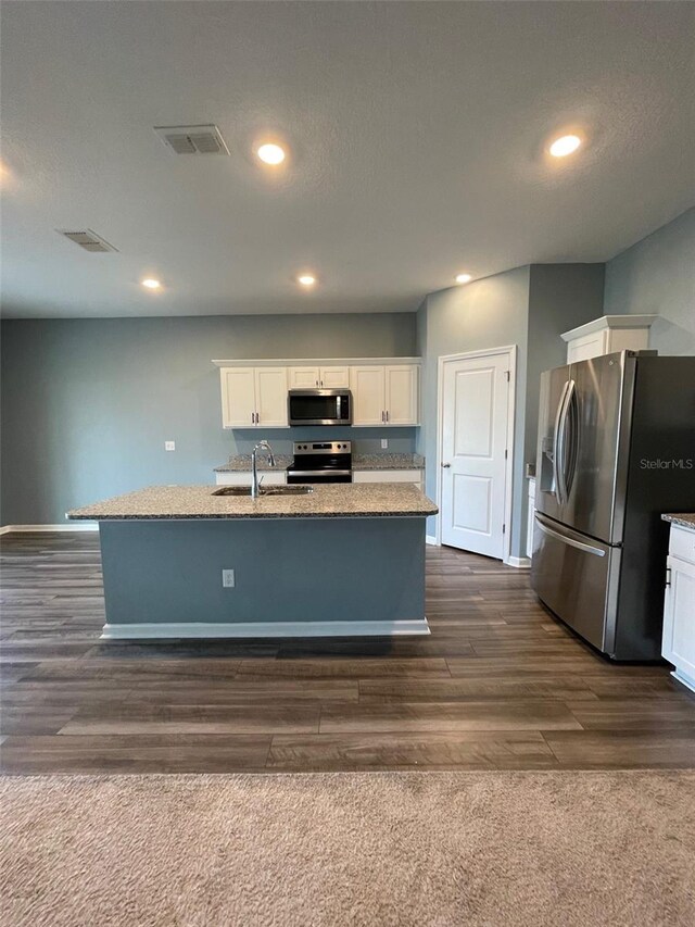 kitchen featuring white cabinetry, sink, dark hardwood / wood-style flooring, a kitchen island with sink, and appliances with stainless steel finishes