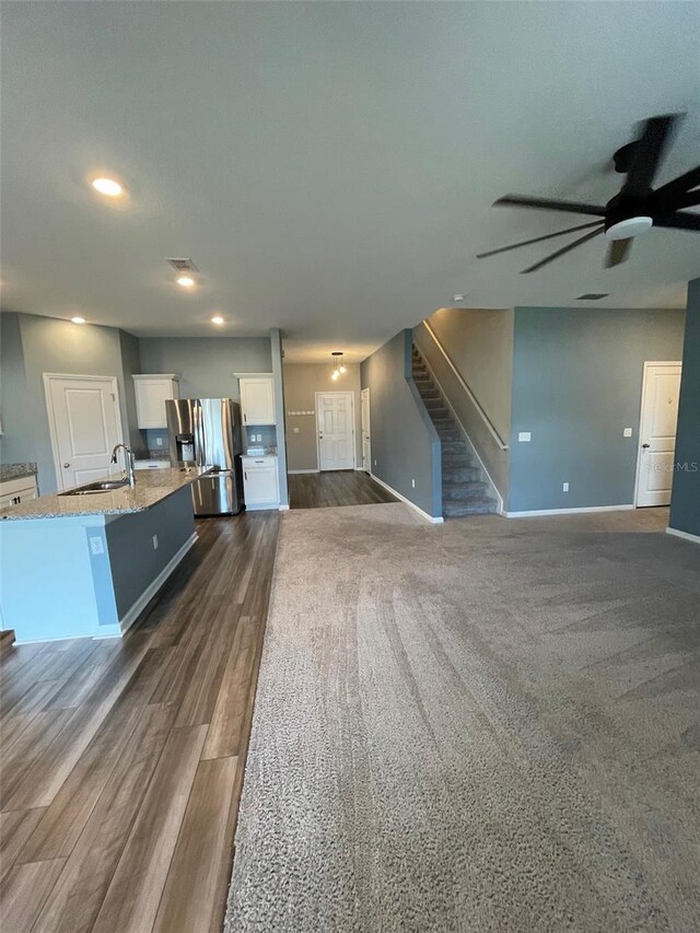 unfurnished living room with ceiling fan, dark hardwood / wood-style flooring, and sink