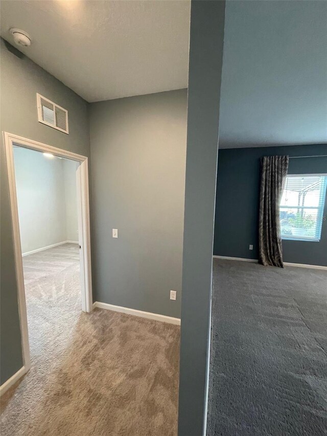 hallway with dark colored carpet