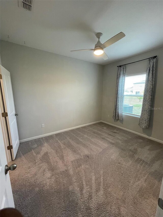 spare room featuring carpet flooring and ceiling fan