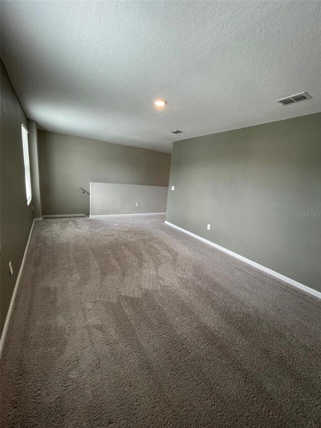 carpeted spare room featuring a textured ceiling