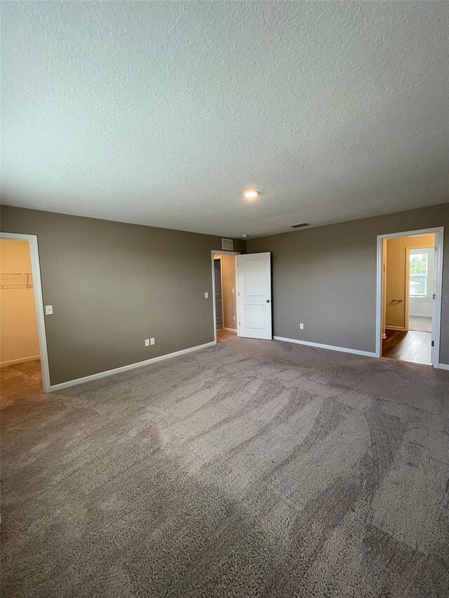 carpeted spare room featuring a textured ceiling