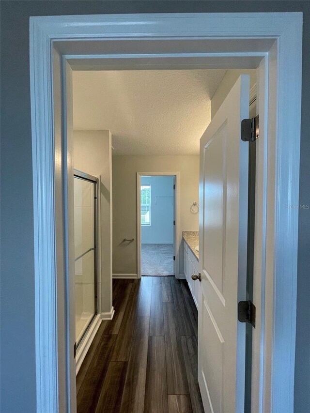 hallway featuring a textured ceiling and dark wood-type flooring