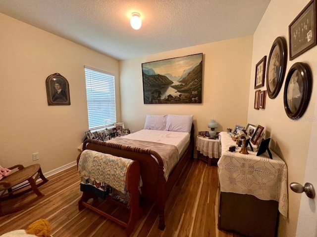 bedroom featuring a textured ceiling and dark wood-type flooring