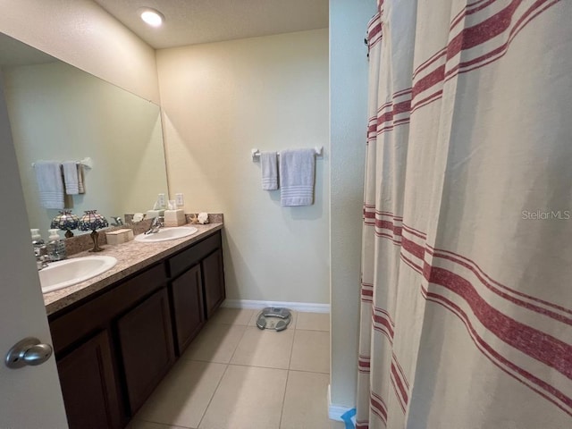 bathroom with vanity with extensive cabinet space, double sink, and tile flooring