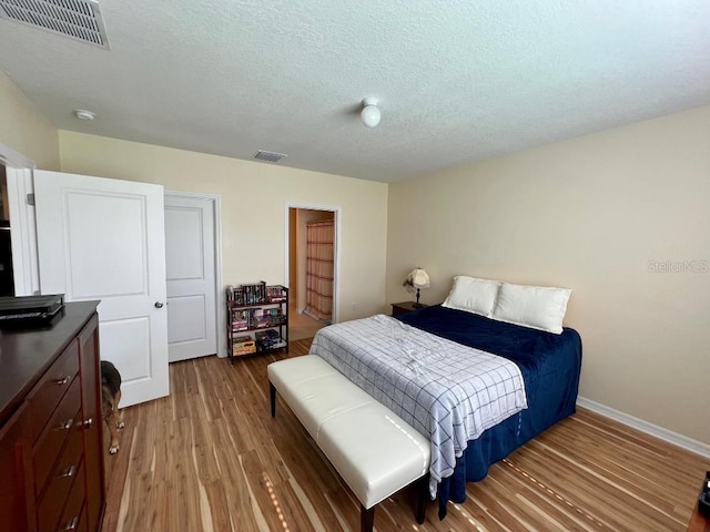 bedroom featuring a textured ceiling and wood-type flooring