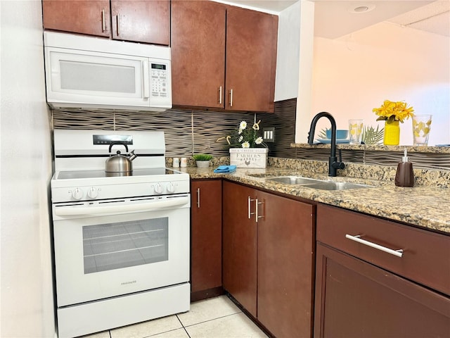 kitchen with stone countertops, sink, backsplash, light tile patterned floors, and white appliances